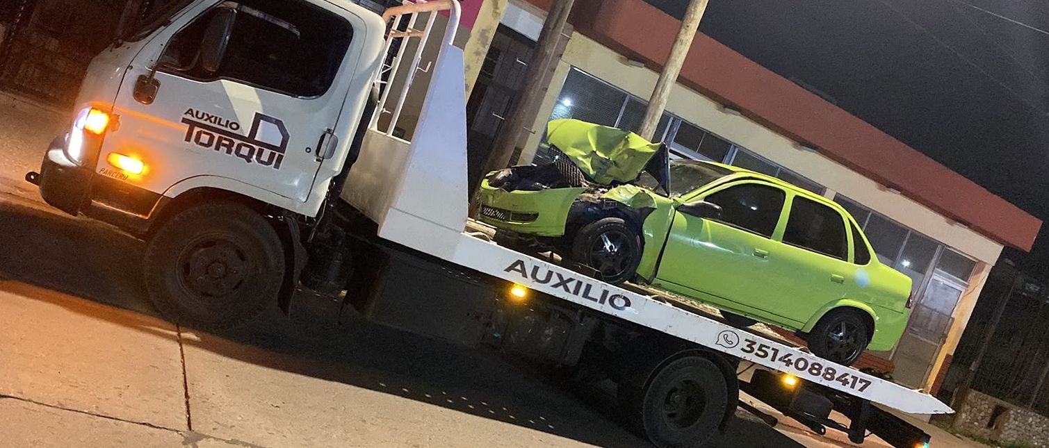 Grúa de Auxilio Torqui de noche, trasladando un auto chocado