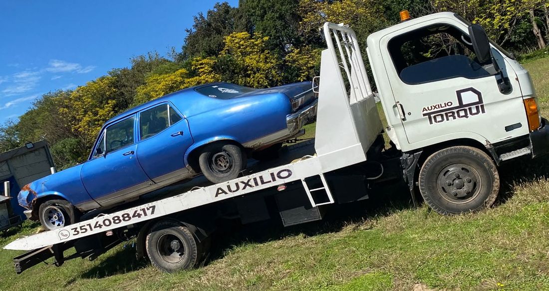 Auto clásico azul cargado en la grúa