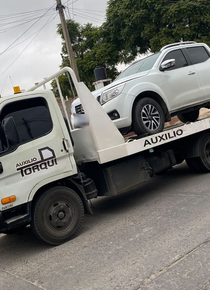 Camioneta blanca sobre la grúa